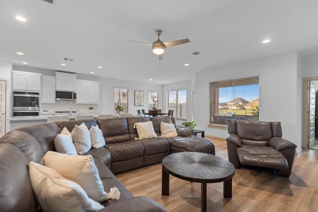 a living room with furniture and a view of kitchen