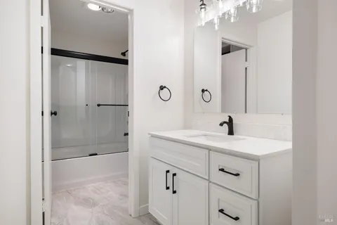 a bathroom with a shower sink and mirror