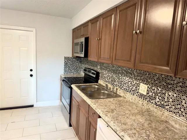 a kitchen with granite countertop a sink stove and cabinets