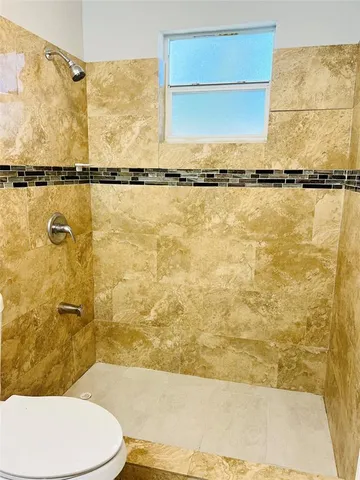 a bathroom with a toilet and a shower