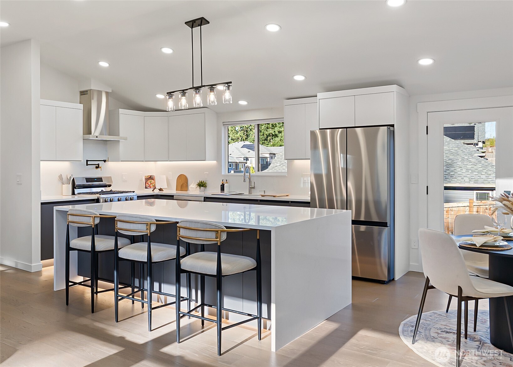 4215 228th Street Southeast Bothell, WA 98021 - Photo 11 of 36 a kitchen with kitchen island a dining table chairs stainless steel appliances and cabinets