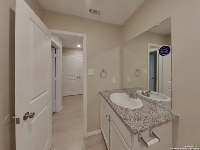 a bathroom with a granite countertop sink a mirror and shower