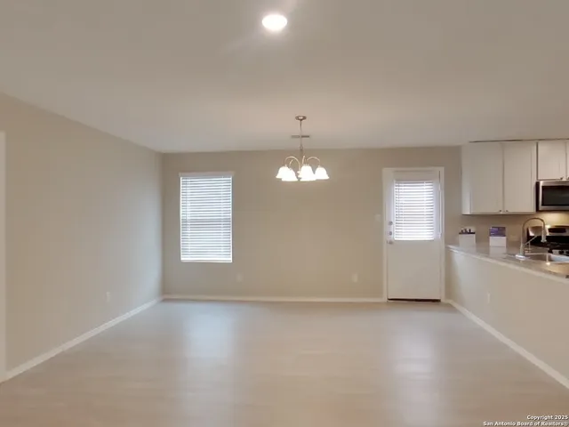 an empty room with a kitchen and a window
