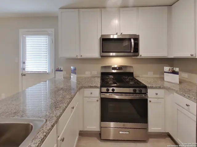 a kitchen with granite countertop a stove and a sink