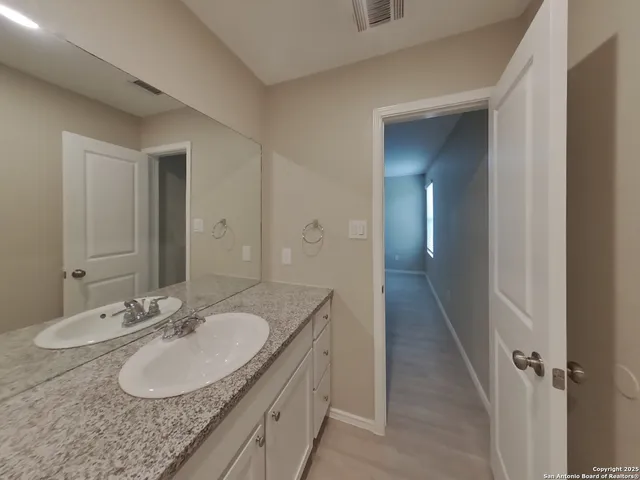 a bathroom with a granite countertop sink and a mirror