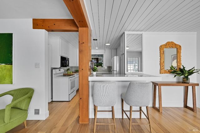 a kitchen with white cabinets and chairs