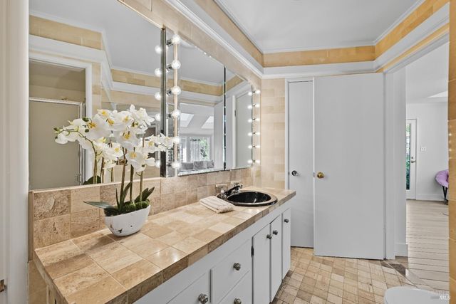 a bath room with sink and natural light