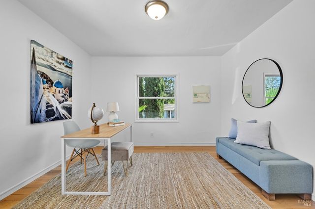 a living room with furniture a window and a wooden floor
