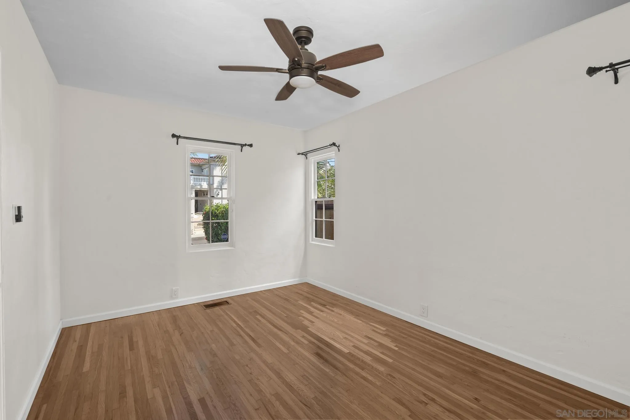 607 Arenas Street La Jolla, CA 92037 - Photo 12 of 37 an empty room with wooden floor ceiling fan and window