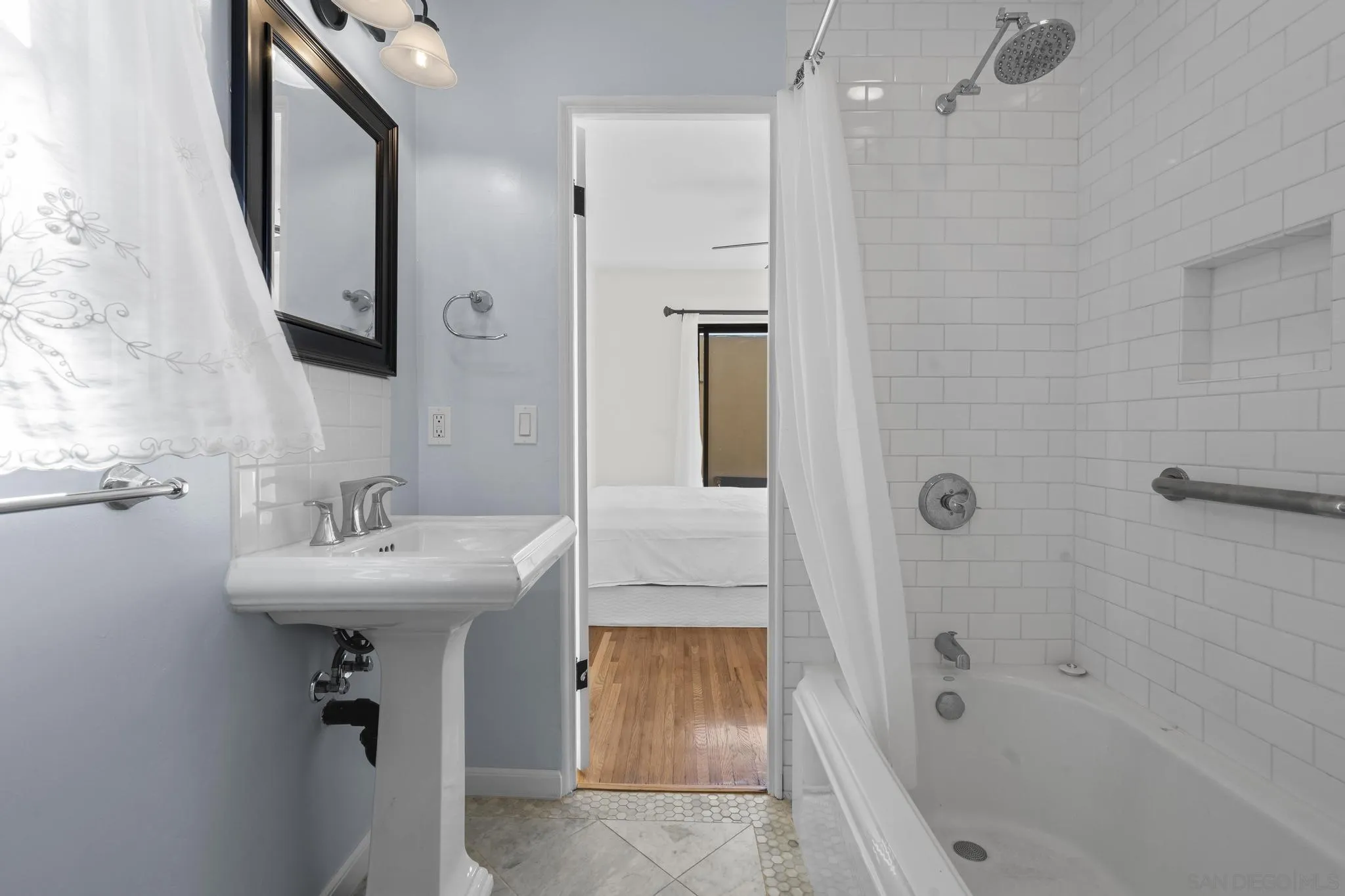 607 Arenas Street La Jolla, CA 92037 - Photo 15 of 37 a bathroom with a sink a mirror a bathtub and shower