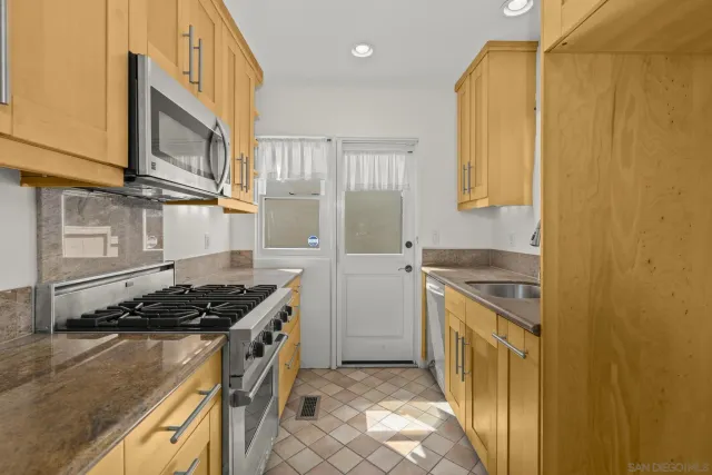 a kitchen with stainless steel appliances granite countertop a stove and a refrigerator