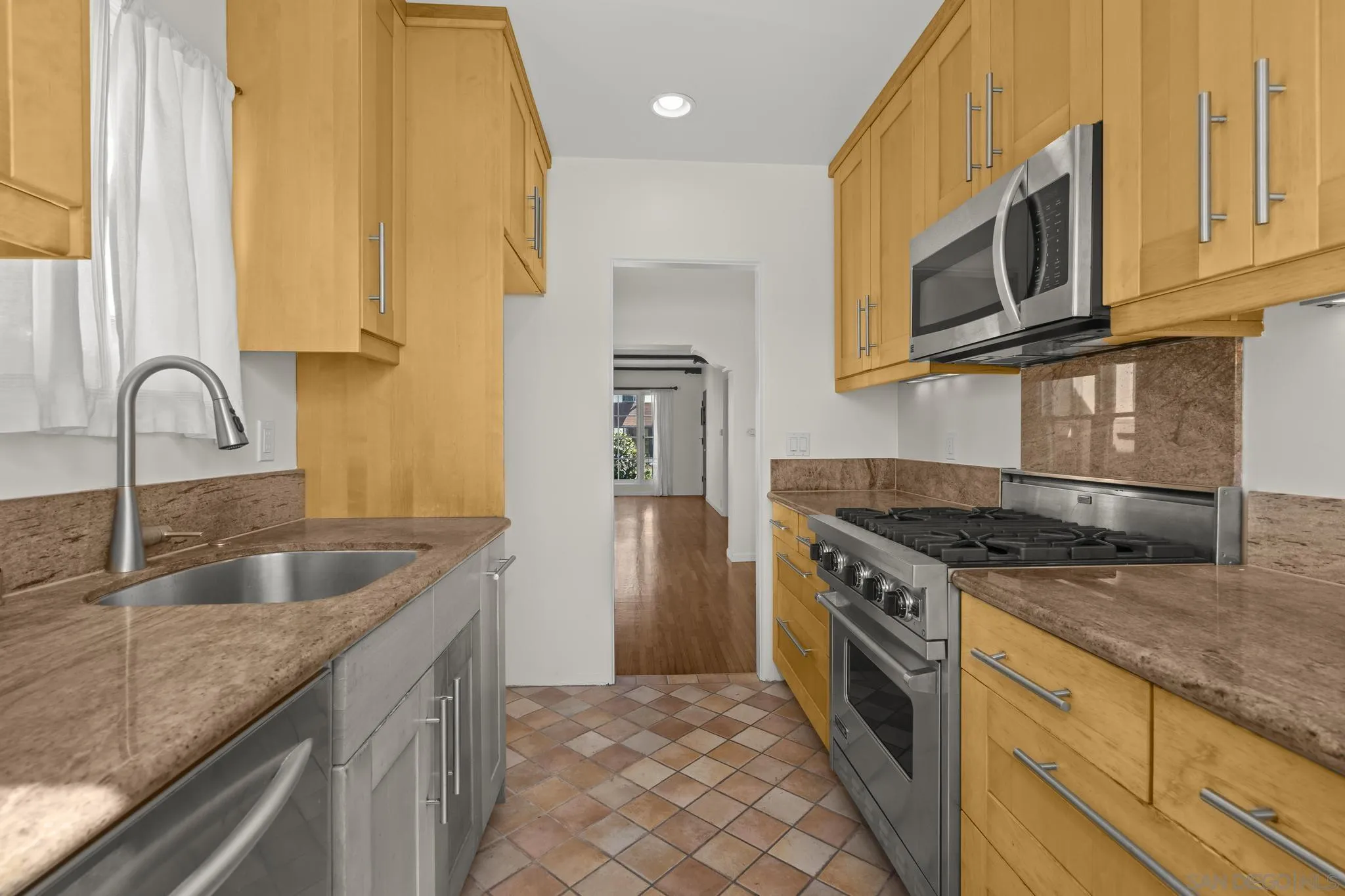 607 Arenas Street La Jolla, CA 92037 - Photo 19 of 37 a kitchen with stainless steel appliances granite countertop a sink and a stove