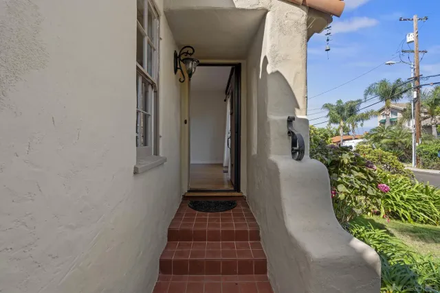 a view of a pathway of a house with potted plants