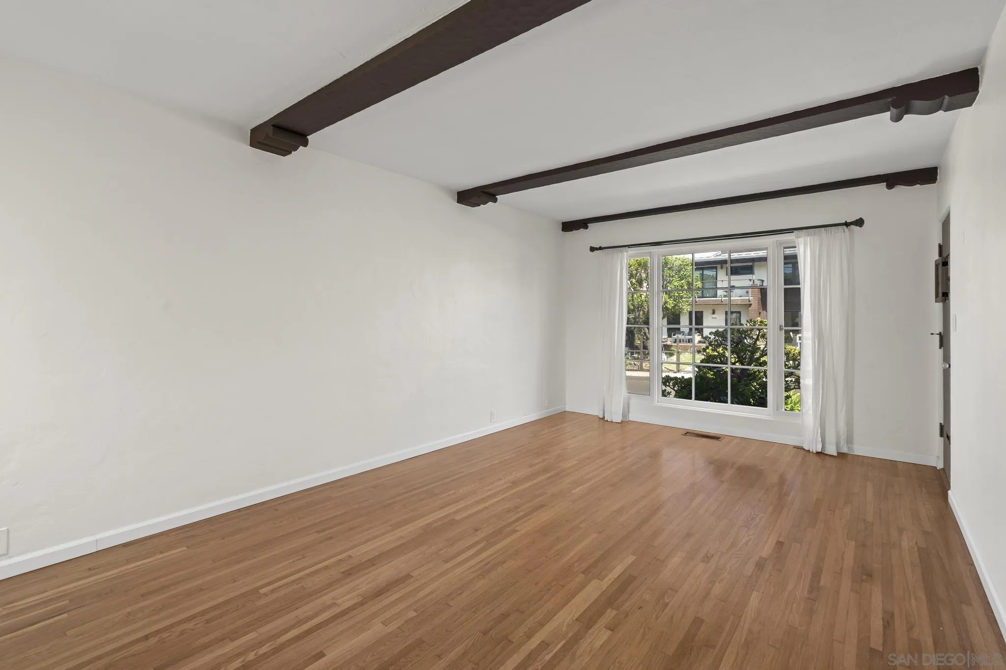 607 Arenas Street La Jolla, CA 92037 - Photo 6 of 37 a view of an empty room with wooden floor and a window