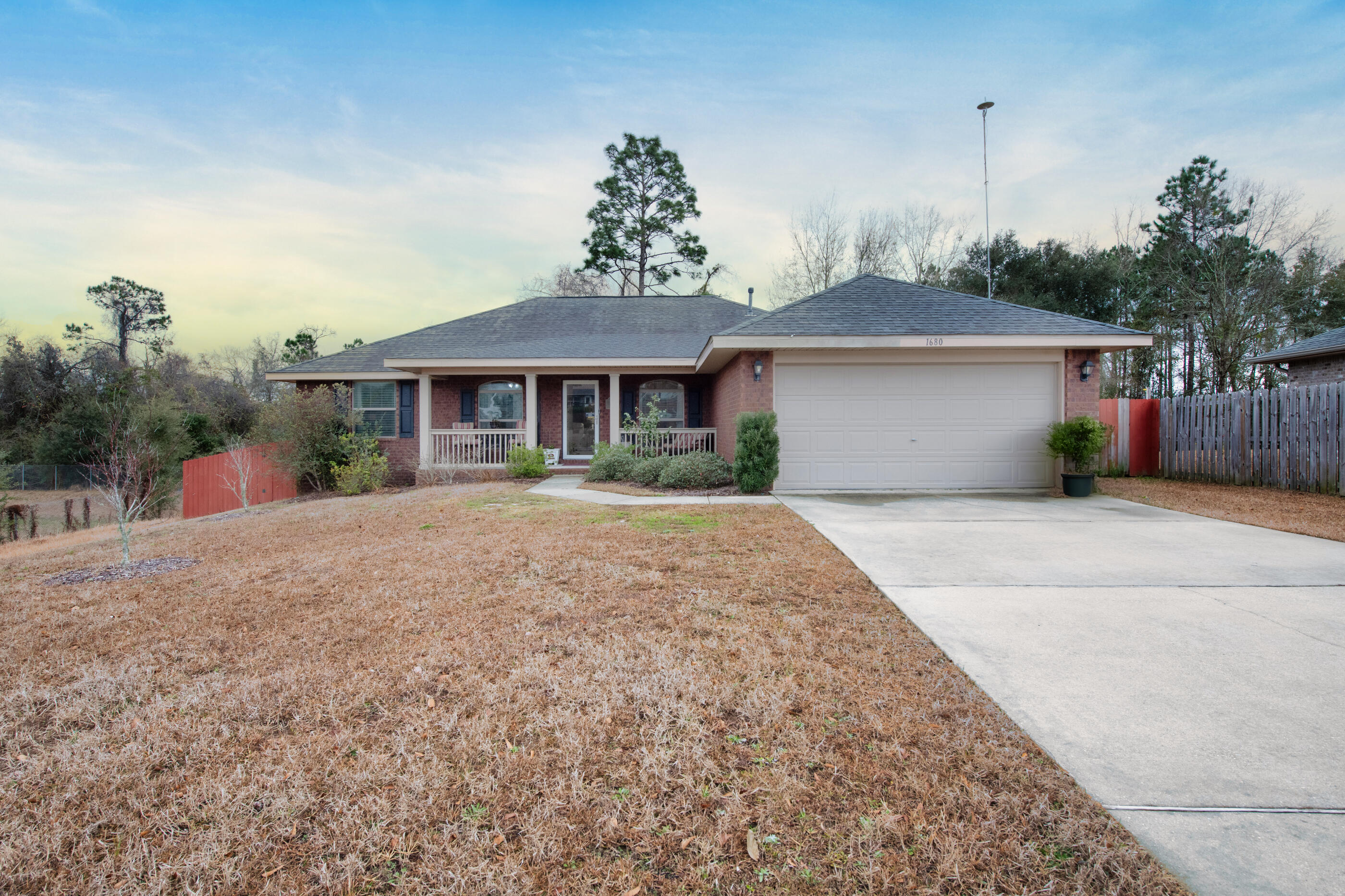 1680 Twin Pines Circle Cantonment, FL 32533 - Photo 2 of 39 a front view of a house with a yard and trees