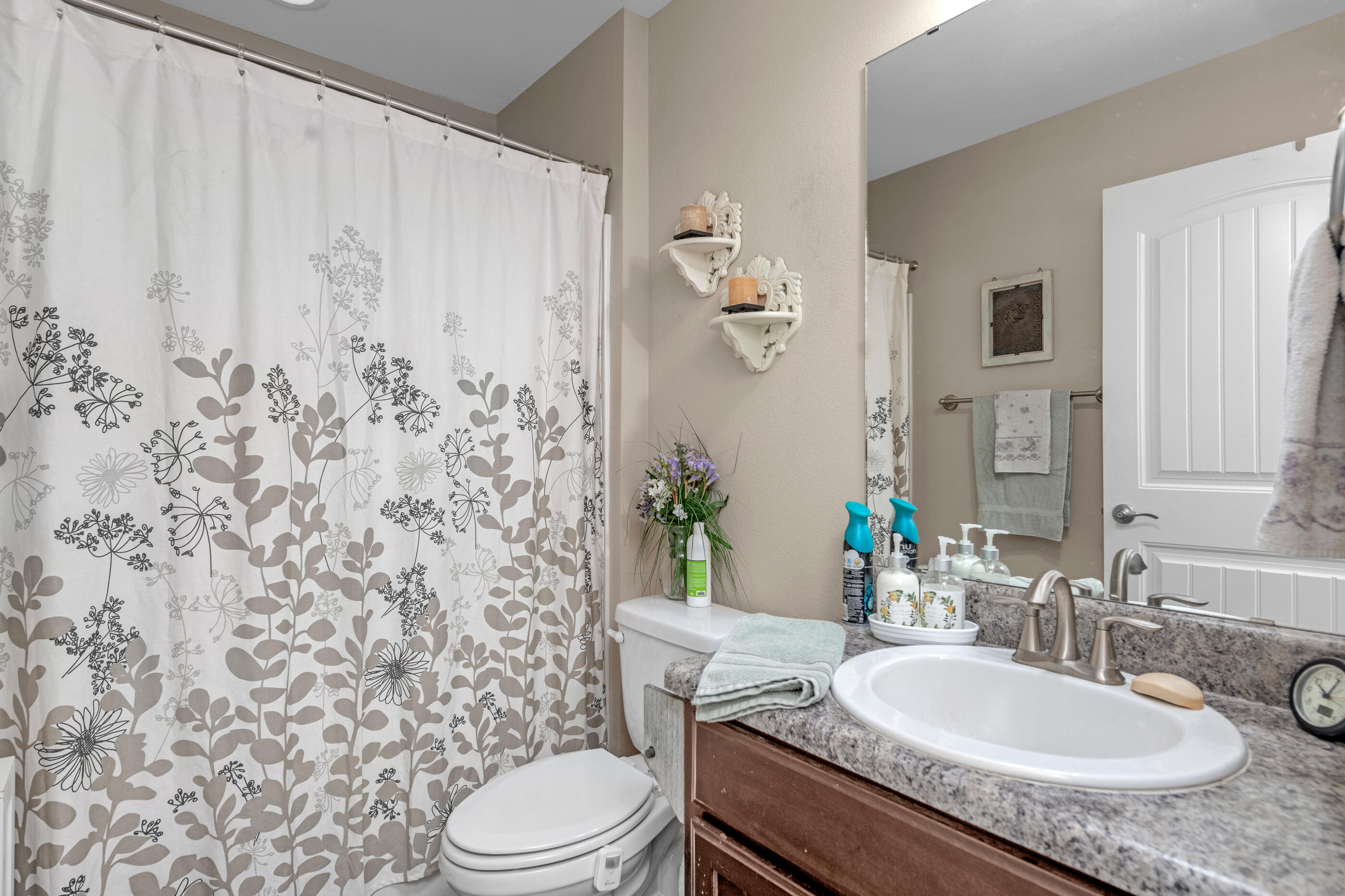 1680 Twin Pines Circle Cantonment, FL 32533 - Photo 38 of 39 a bathroom with a granite countertop sink a toilet and a mirror