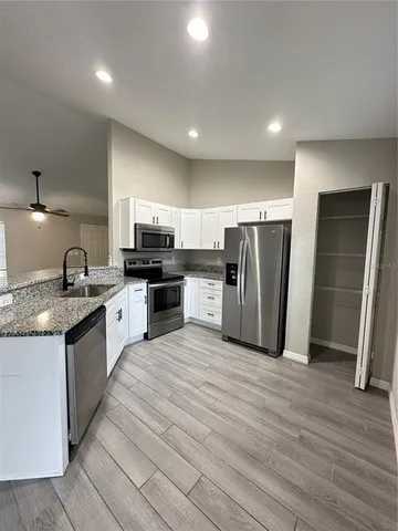 a large kitchen with stainless steel appliances granite countertop a stove a sink and a refrigerator