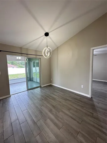 an empty room with wooden floor and window