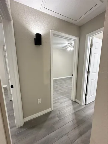 a view of an empty room with wooden floor and a window