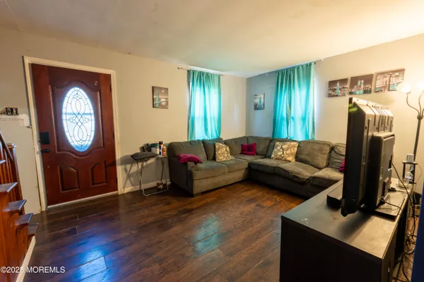 a living room with furniture a large window and a mirror