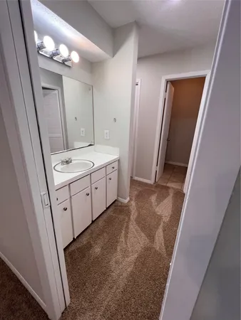 a view of a bathroom with mirror on vanity and a sink