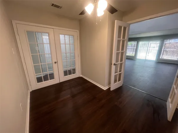 an empty room with wooden floor and windows