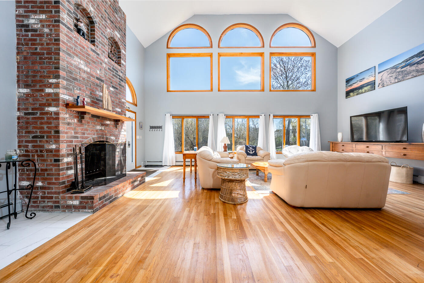 33 Island View Road Hyannis, MA 02601 - Photo 10 of 64 a living room with a couch a fireplace a flat screen tv and windows