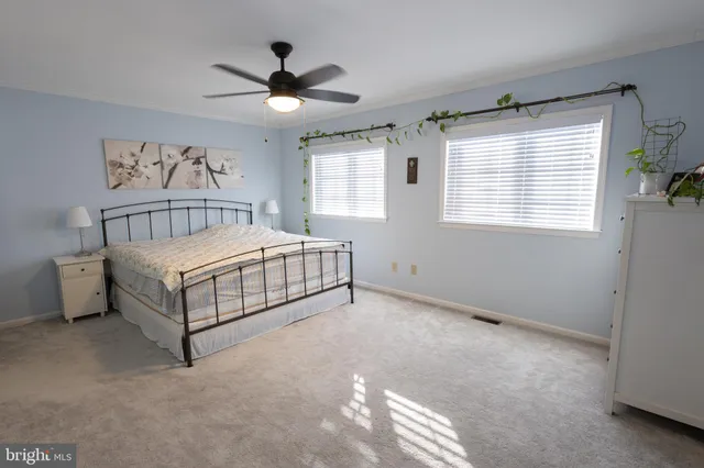a bedroom with a bed and a ceiling fan