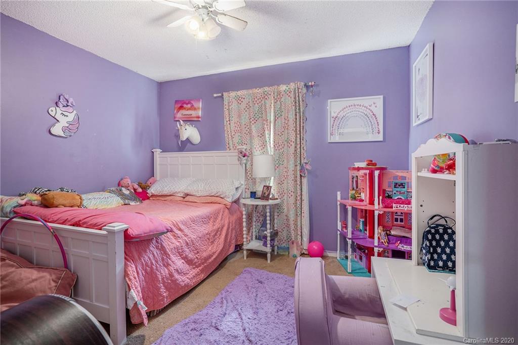 1714 East Sandy Ridge Road Monroe, NC 28112 - Photo 17 of 28 a bedroom with a bed and a chandelier