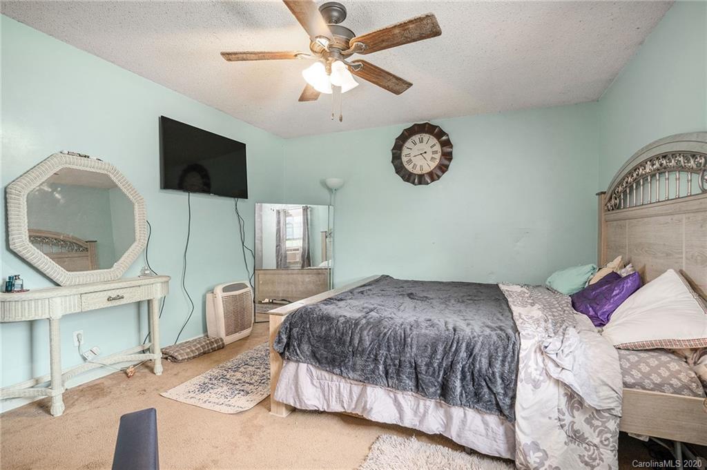 1714 East Sandy Ridge Road Monroe, NC 28112 - Photo 22 of 28 a bedroom with a bed and a chandelier