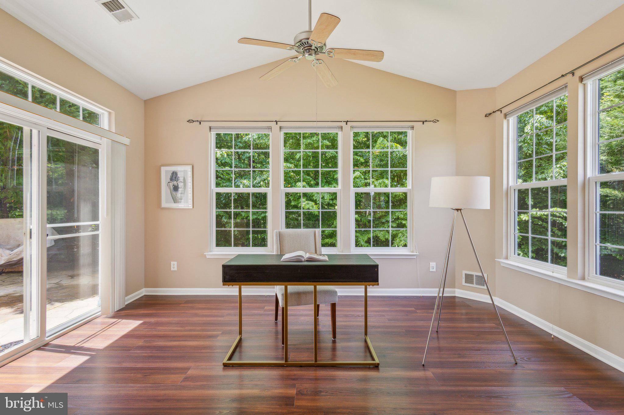 16100 Dancing Leaf Place Dumfries, VA 22025 - Photo 19 of 35 a dining room with wooden floor a chandelier a glass table and windows