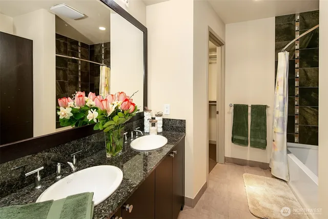 a bathroom with a granite countertop sink a toilet and shower