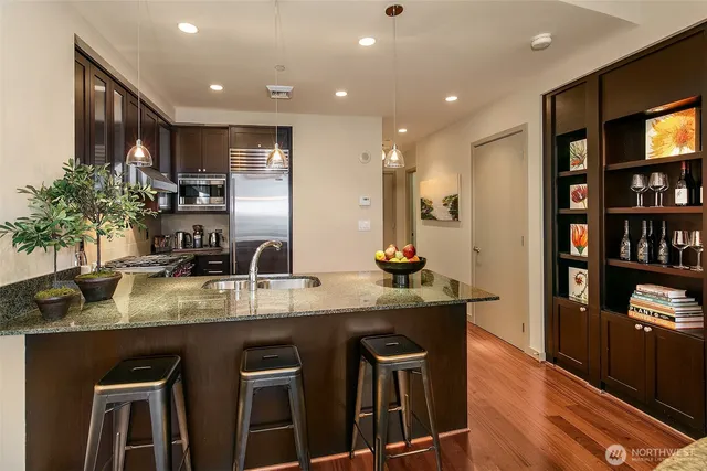 a kitchen with stainless steel appliances granite countertop a sink and a refrigerator
