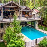 an aerial view of a house with swimming pool and deck