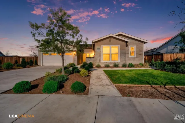 a front view of a house with a yard and potted plants
