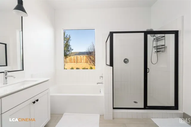a bathroom with a granite countertop sink a mirror a shower and a bathtub