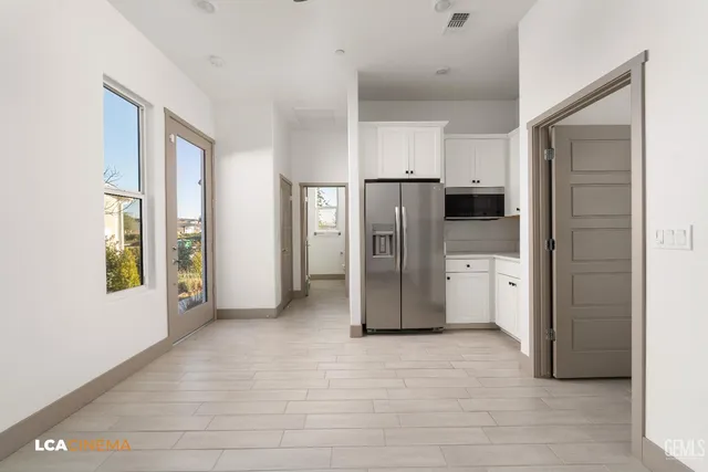 a view of a kitchen with refrigerator and window