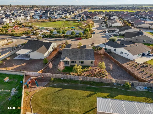 an aerial view of residential houses with outdoor space and swimming pool