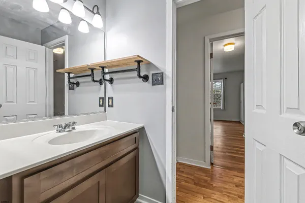 a bathroom with a sink a light fixture and a mirror