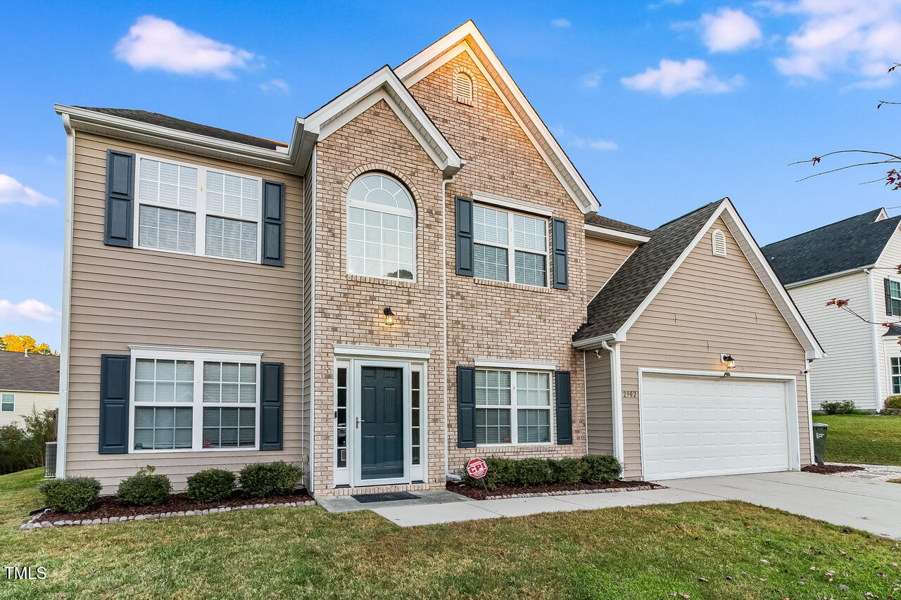 a front view of a house with a yard and plants