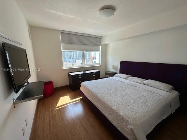 31 Southeast 5th Street, Unit 1908 Miami, FL 33131 - Photo 11 of 43 a bedroom with a bed and wooden floor