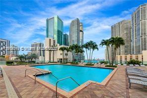 31 Southeast 5th Street, Unit 1908 Miami, FL 33131 - Photo 42 of 43 a view of a swimming pool with a lawn chairs and palm tree