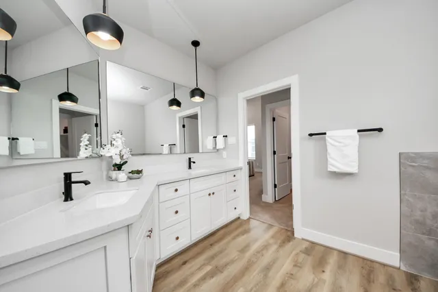 a spacious bathroom with double vanity a sink and a mirror