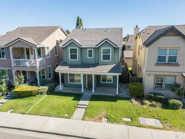 an aerial view of multiple houses with a yard