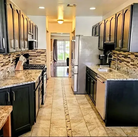 a kitchen with stainless steel appliances granite countertop a stove a sink dishwasher and a refrigerator