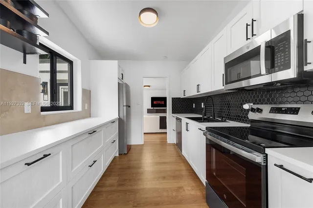 a kitchen with stainless steel appliances kitchen island granite countertop a stove a sink and a microwave