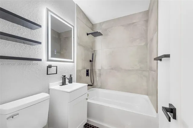 a white bath tub sitting next to a white toilet and a sink
