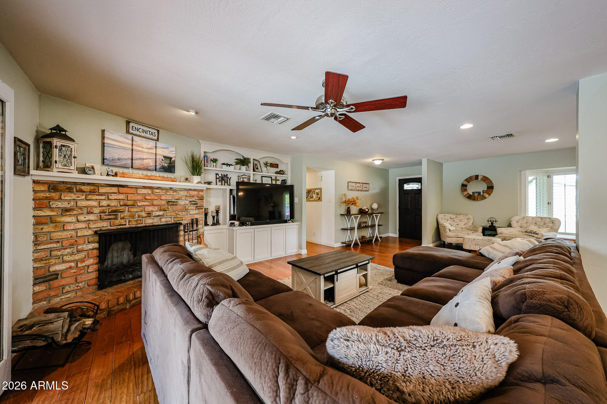 7113 North 8th Avenue Phoenix, AZ 85021 - Photo 11 of 57 a living room with furniture a fireplace and a flat screen tv
