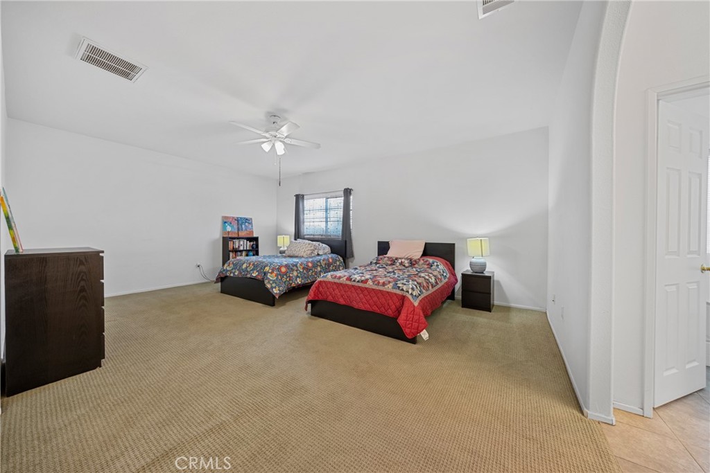 1727 Miranda Lane Beaumont, CA 92223 - Photo 16 of 47 a spacious bedroom with a bed and a chandelier