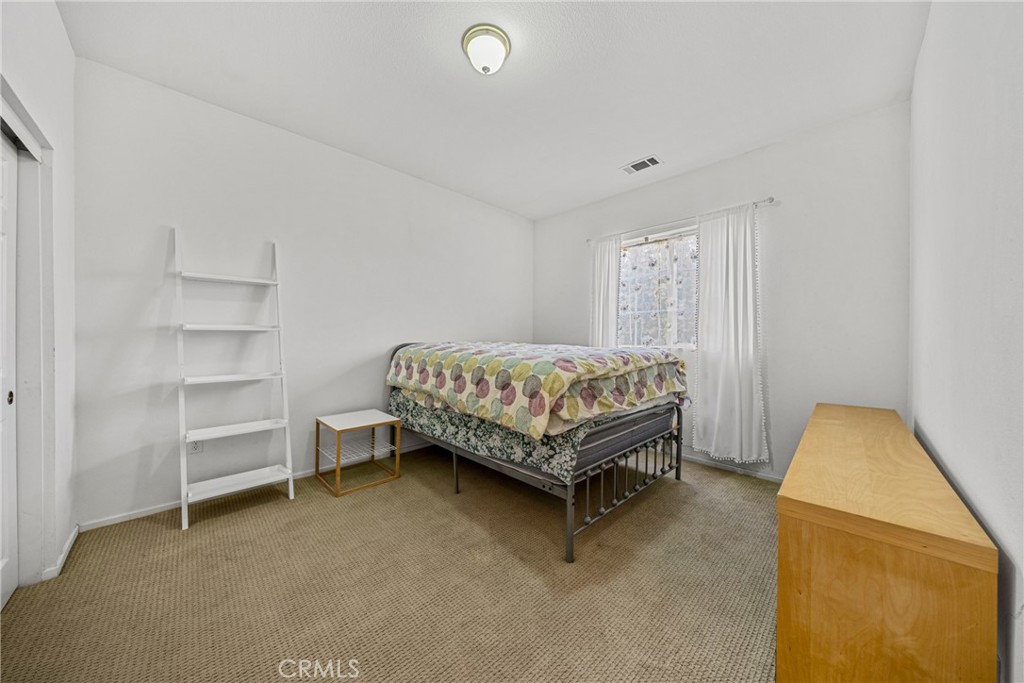 1727 Miranda Lane Beaumont, CA 92223 - Photo 25 of 47 a bedroom with a bed and a chair